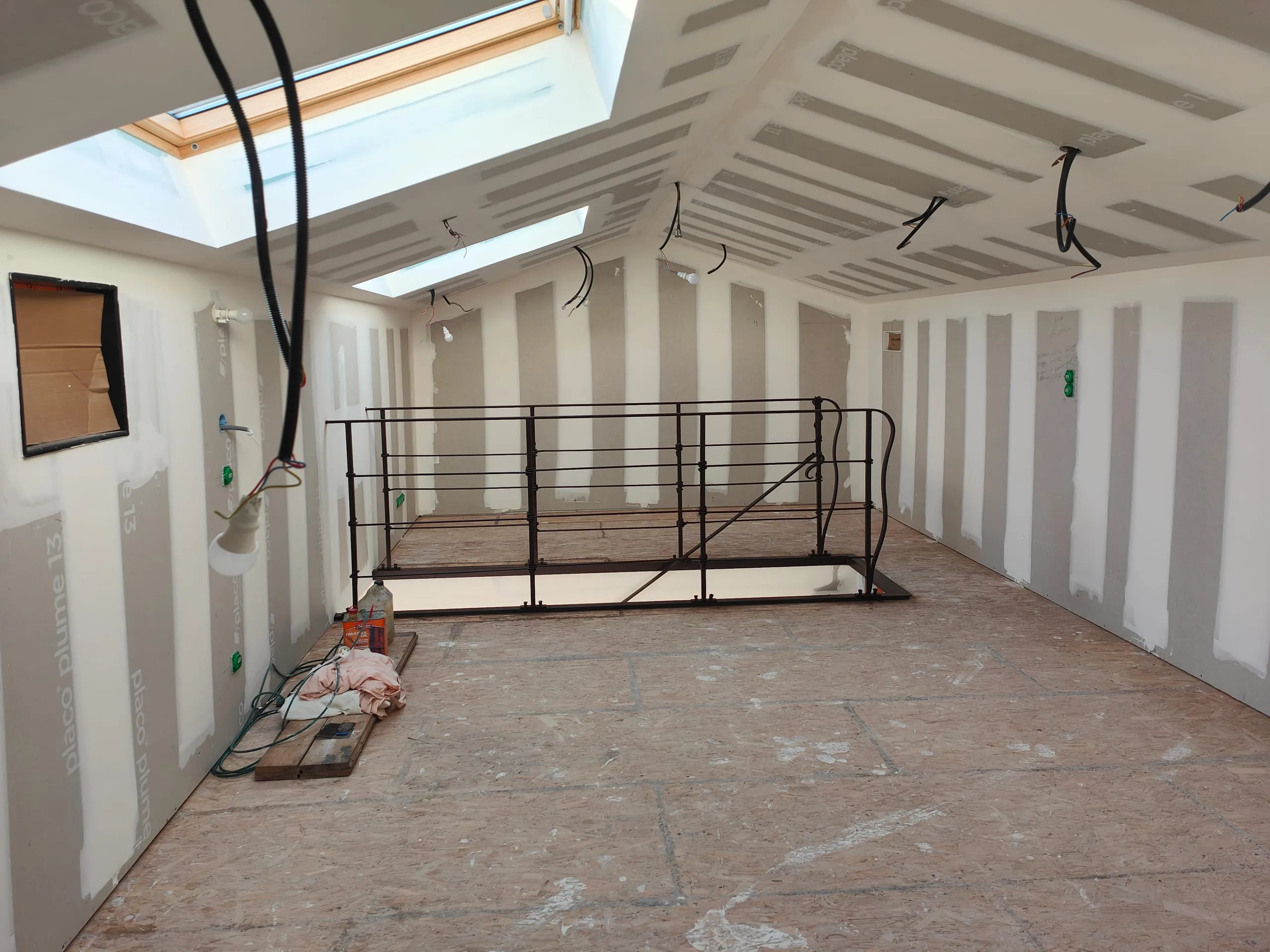 Pose de plaques de plâtre et réalisation de joints dans un intérieur en rénovation par un plaquiste.