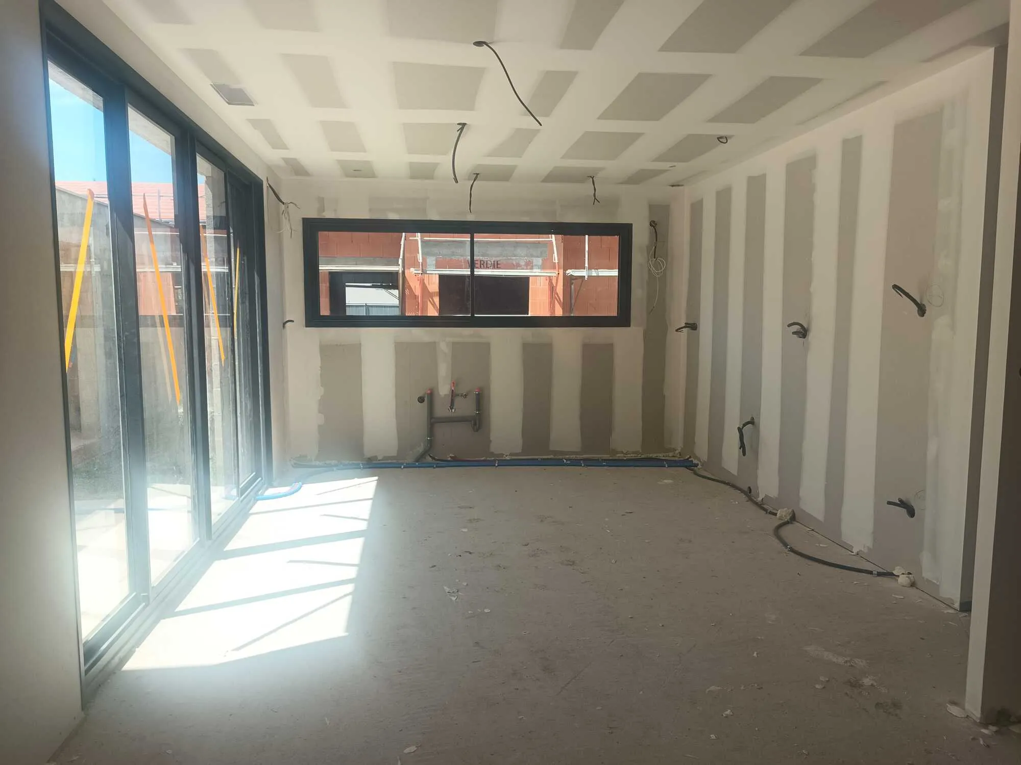 Pièce intérieure en rénovation avec cloisons et plafond en plaques de plâtre jointoyées.