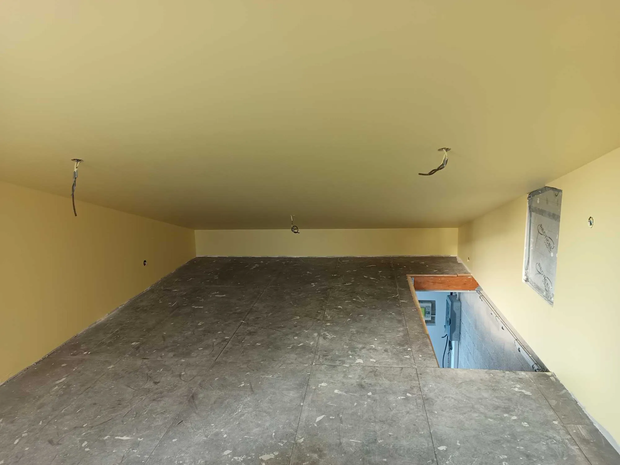 Pièce intérieure en cours d'aménagement avec murs et plafond en plaques de plâtre.